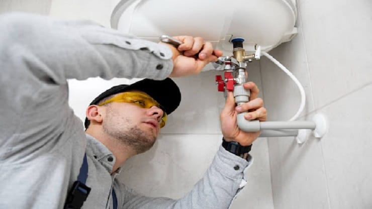 Plumber fixing water heater unit